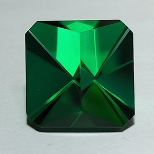 Peut inclure: Une émeraude verte vibrante taillée en forme carrée avec des facettes.