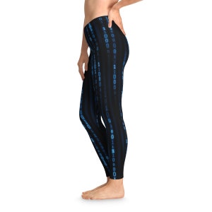 May include: Black leggings featuring a vertical pattern of blue binary code. The leggings are close-fitting and reach the ankles. The binary code design is a repeating pattern of ones and zeros.