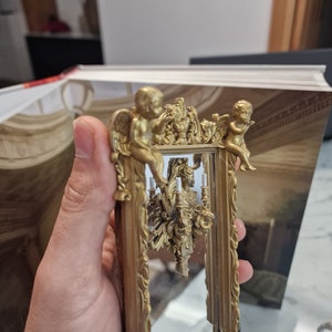 Dollhouse mirror with angels and candelabra.