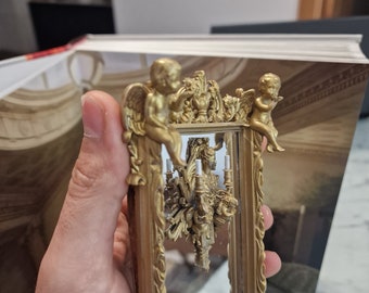 Miroir de maison de poupée avec anges et candélabres.