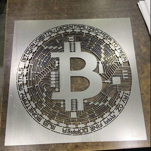 May include: A silver metal cutout of a Bitcoin logo with the text "Cryptocurrency Fine Digital Decentralized Peer to Peer Bitcoin Digital Metals Money",  "french":