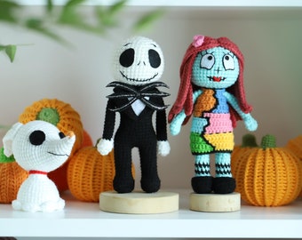 May include: Crocheted plush toys of Jack Skellington, Sally, and Zero from the Nightmare Before Christmas movie. The toys are standing on a white shelf with orange crocheted pumpkins.