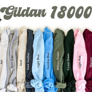 May include: A variety of Gildan 18000 sweatshirts in different colors, including white, ash, sport grey, sand, dark heather, light blue, carolina blue, military green, forest green, light pink, maroon, and black.