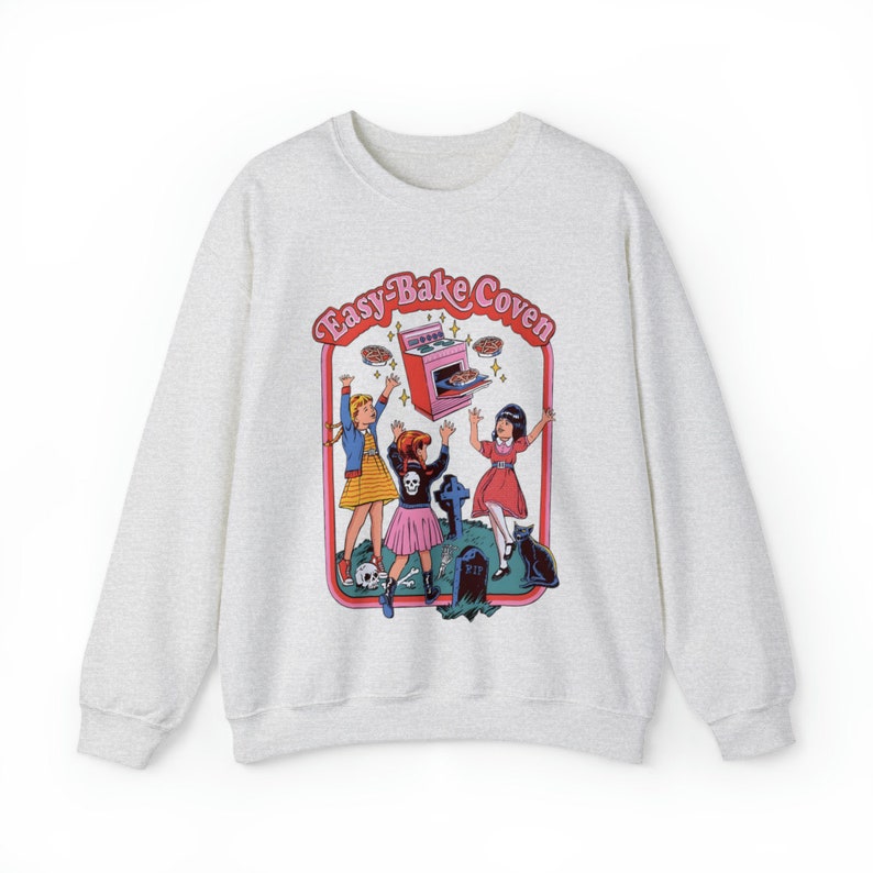 May include: A gray sweatshirt with a graphic print of three girls in front of an oven with the text "Easy-Bake Coven".