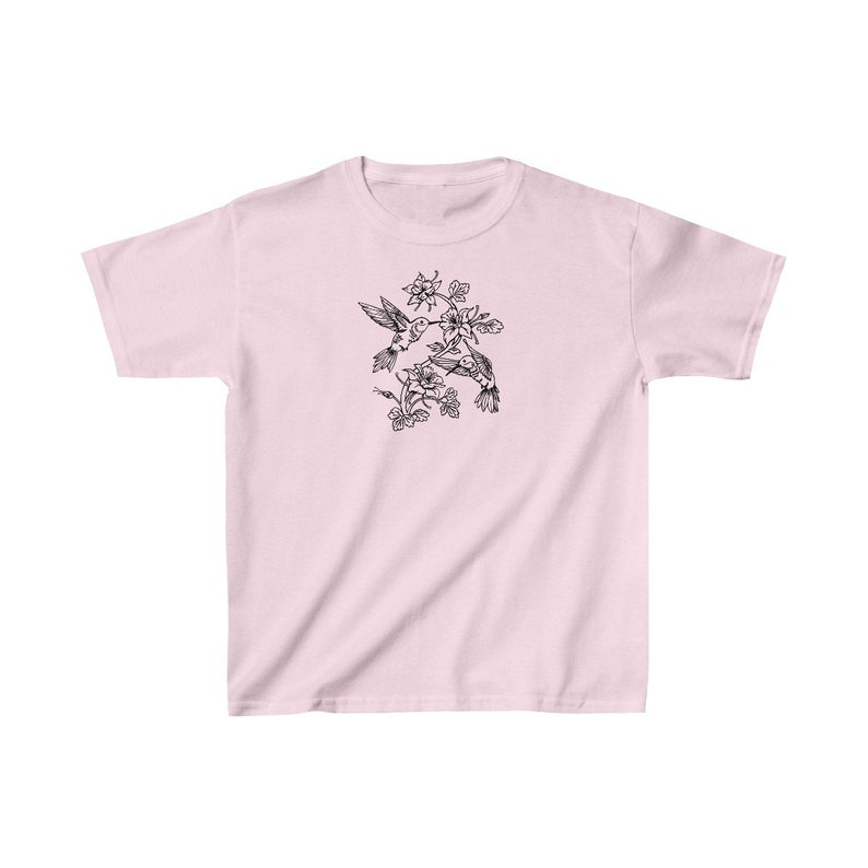 K&ouml;nnte beinhalten: Ein pinkfarbenes T-Shirt mit einer schwarz-wei&szlig;en Illustration von zwei Kolibris im Flug, mit Blumen und Bl&auml;ttern.