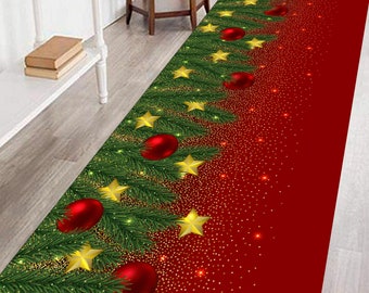 Op de afbeelding: Een rechthoekig kersttapijt met een feestelijk ontwerp. Het tapijt toont een groen kerstboompatroon versierd met rode ballen en gouden sterren tegen een rode achtergrond met gouden glitter.