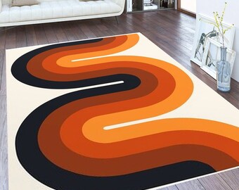 May include: A white rug with a large orange, brown, and black abstract design. The design is a series of curved lines that resemble a wave or a river.
