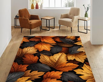 May include: A rectangular area rug featuring a repeating pattern of autumn leaves in shades of orange, yellow, and gray against a black background. The rug is placed on a light-colored wooden floor, with two armchairs and side tables in the background.