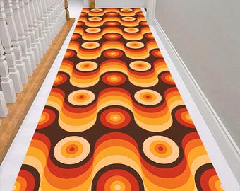 May include: A retro-style runner rug with a wavy pattern in shades of orange, brown, and yellow. The rug features a repeating design of circles and waves.