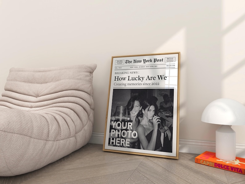 K&ouml;nnte beinhalten: Ein Schwarzwei&szlig;-Zeitungsdruck mit der Schlagzeile "How Lucky Are We" und dem Text "Creating memories since 2022". Die Zeitung ist gerahmt und hat ein Foto von zwei Frauen in der unteren H&auml;lfte. Der Text "YOUR PHOTO HERE" ist in der Mitte des Fotos gedruckt.
