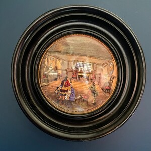 Puede incluir: Una ilustración enmarcada de la casa en la que nació Shakespeare en Stratford-upon-Avon. La ilustración está en un marco redondo negro con un borde dorado.