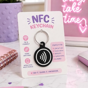 May include: A black circular NFC keychain with a white signal icon, attached to a silver metal ring. The keychain is mounted on a white display card featuring the text NFC KEYCHAIN, TAP & CONNECT, SHARE ANYTHING, WORKS WITH MOST DEVICES, and TAP IT. SHARE IT. ANYWHERE.