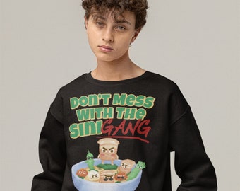Può includere: Felpa nera con la scritta "DON'T MESS WITH THE SINI GANG" in verde e rosso. La grafica presenta una ciotola di cibo con personaggi dei cartoni animati. La felpa è indossata da una persona.