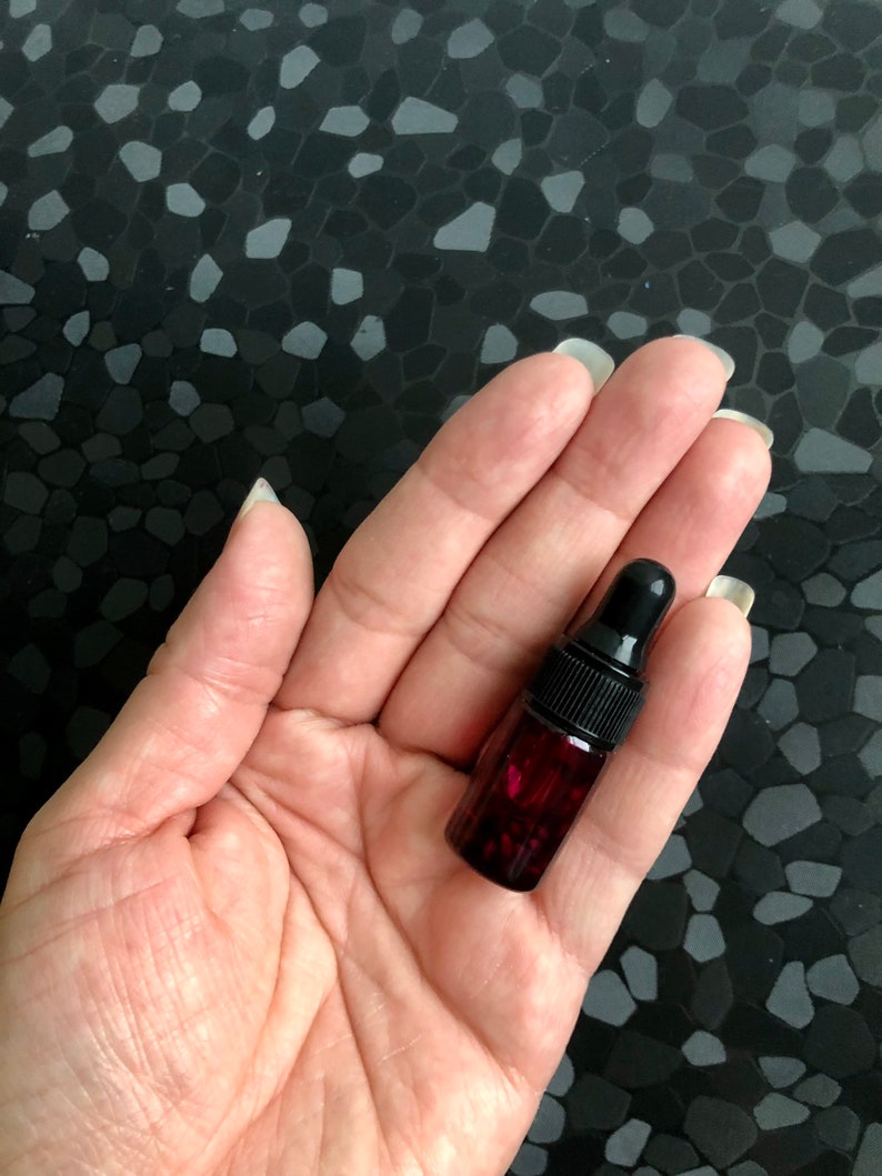 Peut inclure: Un petit flacon en verre rouge fonc&eacute; avec un compte-gouttes noir. Le flacon est rempli d'un liquide rouge fonc&eacute;.
