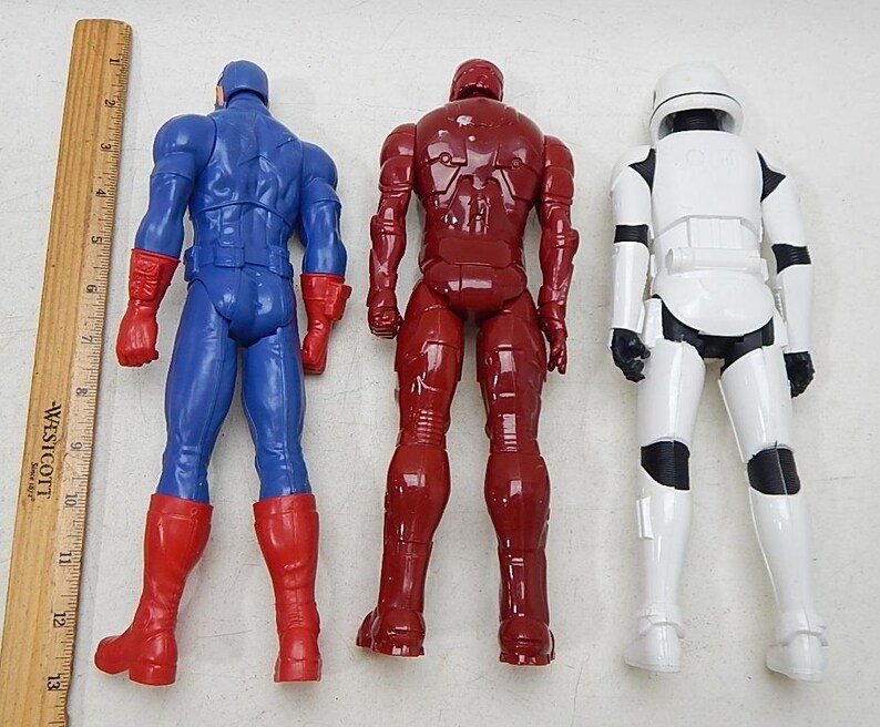 May include: Three action figures, Captain America in blue and red, Iron Man in red, and a Stormtrooper in white.