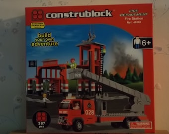 May include: A red and gray fire station playset with a fire truck, ladder, and a fire station building. The set is made of plastic building blocks and includes 387 pieces. The box has the text "construblock" and "Fire Department Fire Station Ref. 46170" on it.