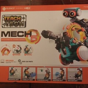 Puede incluir: Un kit de robot de codificaci&oacute;n mec&aacute;nica Teach Tech Mech 5 con m&aacute;s de 220 piezas. El robot es azul, verde, negro y naranja. La caja muestra el robot en diferentes configuraciones, incluyendo dibujo, carretilla elevadora, lanzamiento, agarre y f&uacute;tbol.