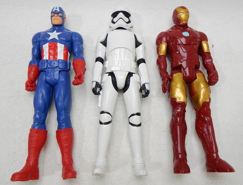 May include: Three action figures: Captain America in a blue and red suit, a white Stormtrooper, and Iron Man in a red and gold suit.