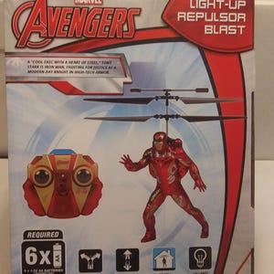 May include: A red, white and gold Iron Man flying figure infrared helicopter toy with a light-up repulsor blast. The helicopter is controlled by a red, white and gold remote control. The box features the Marvel Avengers logo and the text "Light-up Repulsor Blast".