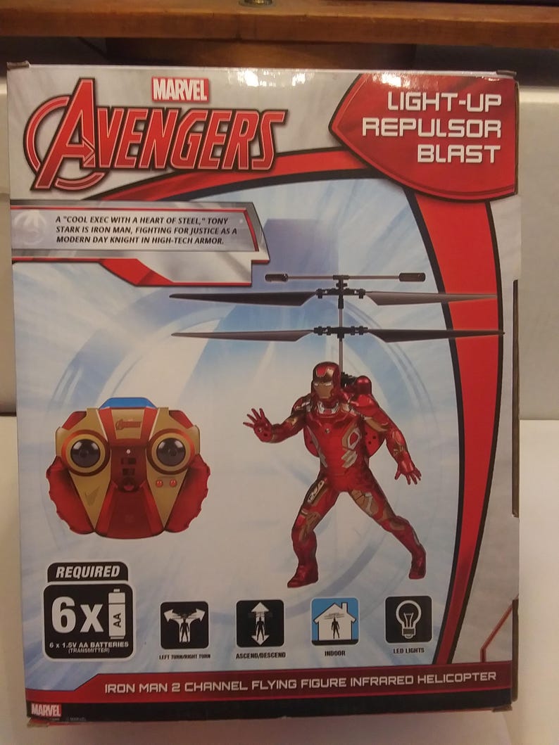 May include: A red, white and gold Iron Man flying figure infrared helicopter toy with a light-up repulsor blast. The helicopter is controlled by a red, white and gold remote control. The box features the Marvel Avengers logo and the text "Light-up Repulsor Blast".