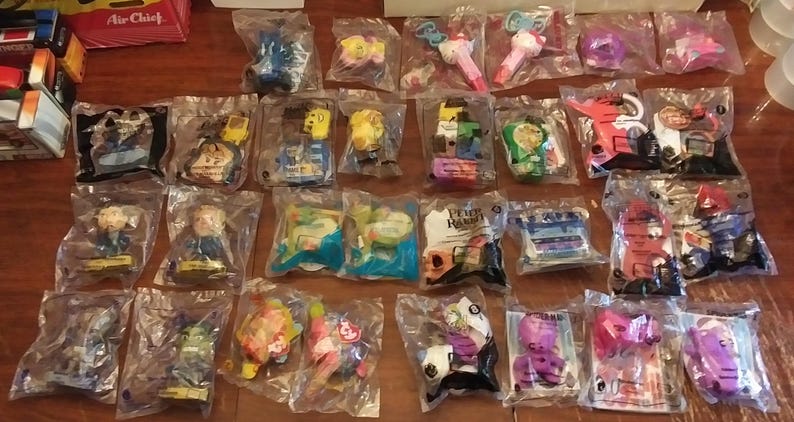 Puede incluir: Una colecci&oacute;n de 24 bolsas de pl&aacute;stico que contienen varios juguetes y baratijas. Los juguetes son en su mayor&iacute;a peque&ntilde;os y coloridos, y est&aacute;n empaquetados en bolsas de pl&aacute;stico transparentes con etiquetas blancas. Algunos de los juguetes incluyen un coche azul, una varita rosa, un personaje amarillo y un personaje verde.