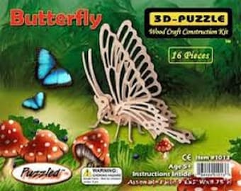 May include: A 3D wooden puzzle kit of a butterfly with 16 pieces. The box features a colorful illustration of a butterfly and mushrooms. The text on the box reads "Butterfly 3D-Puzzle Wood Craft Construction Kit 16 Pieces Puzzled".