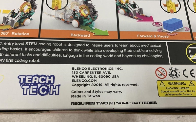Puede incluir: Un kit de robot de codificaci&oacute;n Teach Tech con un robot verde y naranja, un port&aacute;til azul y blanco y un bloque azul. La caja tiene el texto "Teach Tech" y "Requires Two (2) "AAA" Batteries".