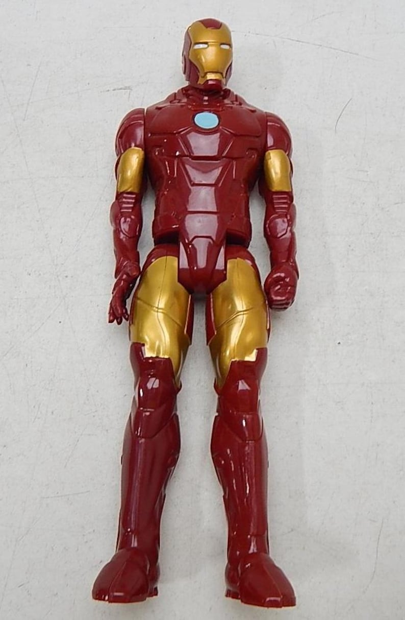 May include: Red and gold plastic action figure of Iron Man. The figure has a red and gold suit with a blue arc reactor on the chest.