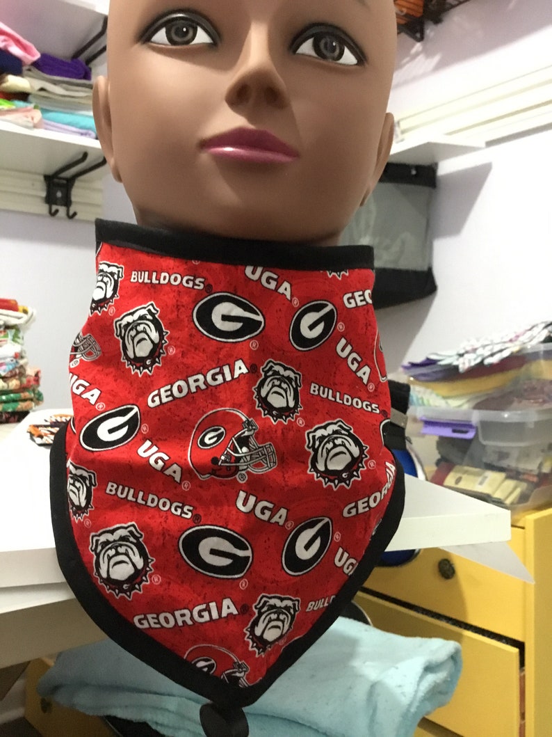 May include: Red and black bandana with a repeated pattern of the University of Georgia logo, the words "Georgia Bulldogs", and a bulldog mascot.