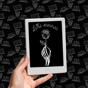 Pode incluir: Uma imagem em preto e branco de uma mão esquelética segurando uma rosa com o texto "Little Mouse" exibido em um leitor de e-books Kindle.