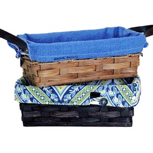 May include: Three woven baskets with fabric liners. The top basket is brown with a blue denim liner. The middle basket is black with a blue and green floral liner. The bottom basket is brown with a blue and green floral liner. The top basket has the text "Sunshine Baskets" on the liner.