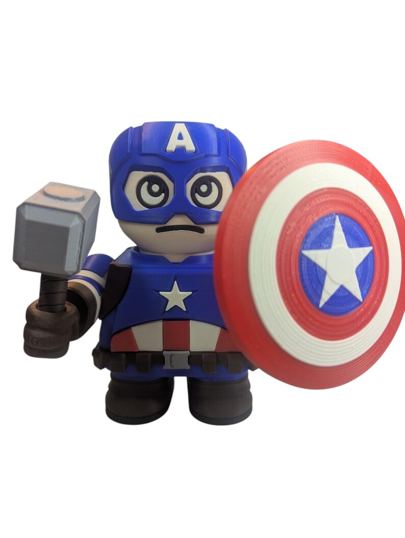 May include: A blue, red, and white Captain America figurine holding a gray hammer and a shield. The figurine has a blue helmet with a white "A" and a star on the chest. The shield is red, white, and blue with a white star.