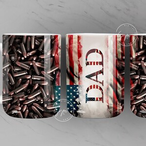 May include: Three white ceramic mugs featuring an American flag design with bullet casings. The central mug displays the word "DAD" in large lettering.