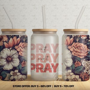 Op de afbeelding: Drie frosted glazen bekers met bamboe deksels en rietjes. De bekers hebben een bloemenmotief met roze, witte en groene bloemen. Een beker heeft de tekst "PRAY on it PRAY over it PRAY through it" in roze letters.