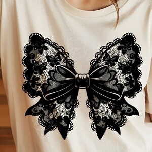 May include: A black lace bow with butterfly details on a white t-shirt.