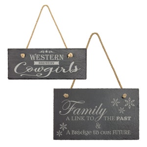 May include: Two black slate signs with rope hangers. The top sign reads "Western Brewery Cowgirls". The bottom sign reads "Family A Link to the Past & A Bridge to our Future".