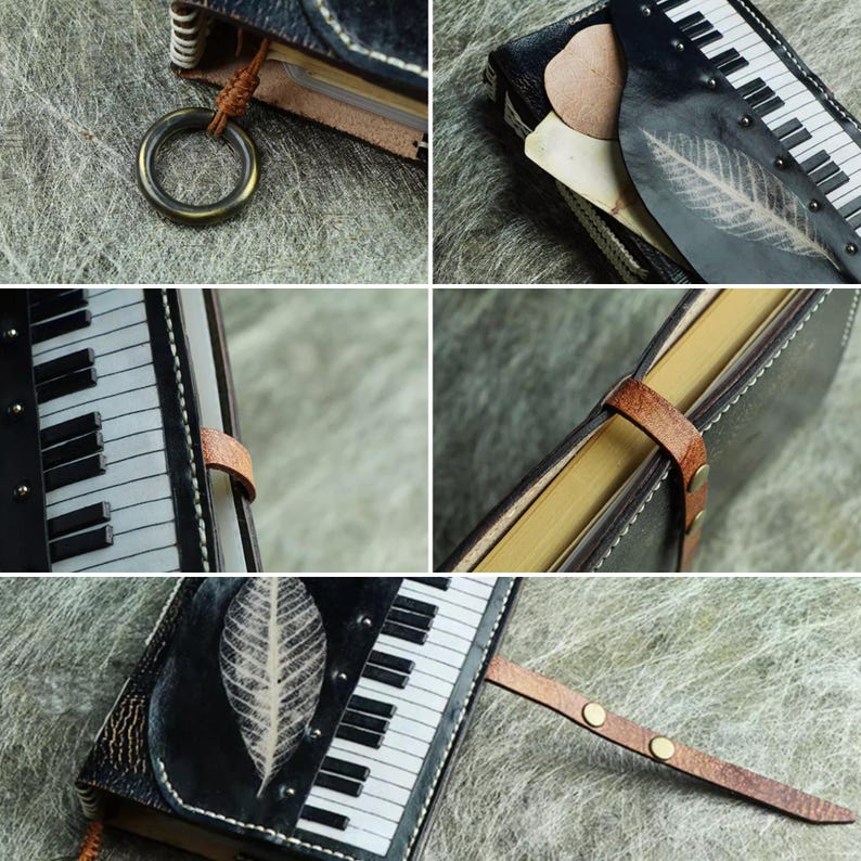 Pu&ograve; includere: Un diario in pelle nera con un design a tastiera di pianoforte e un'impronta di foglia. Il diario ha una chiusura con cinturino in pelle marrone e un anello di metallo. Le pagine sono ingiallite e le cuciture sono bianche.