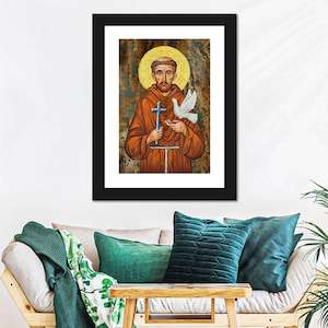 May include: A framed painting of Saint Francis of Assisi, a Catholic saint, holding a cross and a dove. The painting is in a traditional style with a gold background and a textured surface.