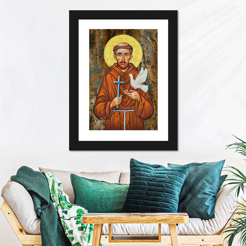 May include: A framed painting of Saint Francis of Assisi, a Catholic saint, holding a cross and a dove. The painting is in a traditional style with a gold background and a textured surface.