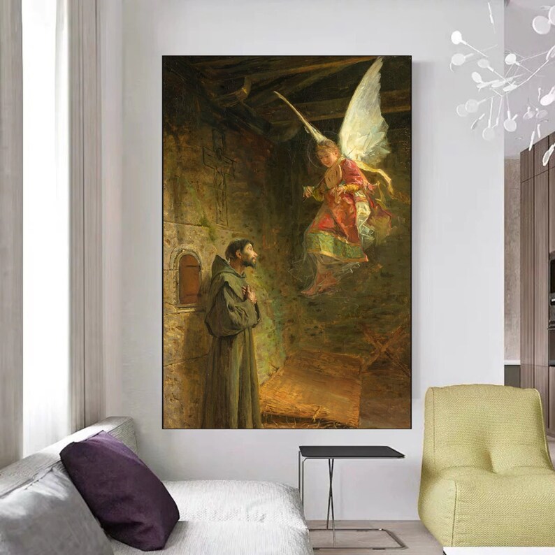 May include: A framed canvas print of a religious painting. The artwork depicts a monk in a brown robe looking up at an angel with large white wings. The angel is wearing a red and gold garment. The background is a dark, stone-walled room.
