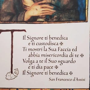 K&ouml;nnte beinhalten: Illustrierte religi&ouml;se Karte mit italienischem Text. Der Text enth&auml;lt einen Segen von San Francesco d'Assisi. Das Bild zeigt eine Person mit gefalteten H&auml;nden und einen floralen Rand. Religi&ouml;ses Objekt.