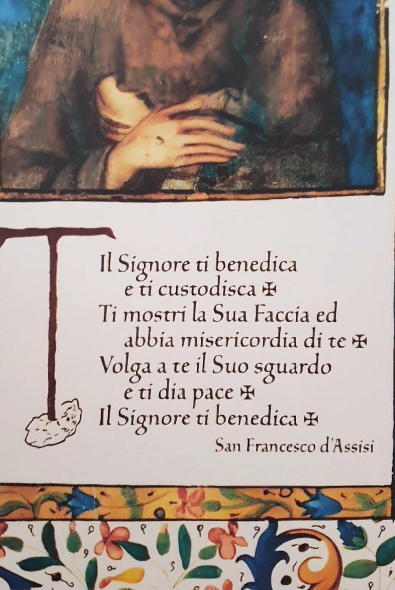 K&ouml;nnte beinhalten: Illustrierte religi&ouml;se Karte mit italienischem Text. Der Text enth&auml;lt einen Segen von San Francesco d'Assisi. Das Bild zeigt eine Person mit gefalteten H&auml;nden und einen floralen Rand. Religi&ouml;ses Objekt.