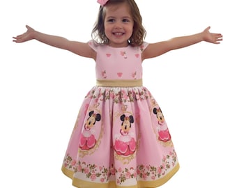 Vestido de lujo de Minnie Royalty con fondo rosa.