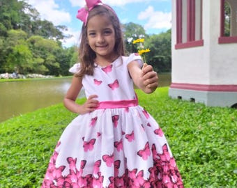 Vestido de lujo con fajín de mariposa rosa.