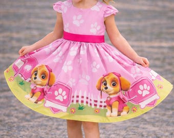 Vestido de lujo de Skye de Paw Patrol con fondo rosa.