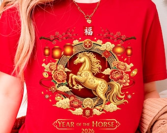May include: Red t-shirt featuring a golden horse design within a circular frame, surrounded by floral and lantern motifs. The text "Year of the Horse 2026" is displayed below the horse. The shirt is short-sleeved.