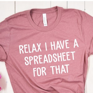 May include: A mauve t-shirt with the text "Relax I have a spreadsheet for that" printed in white.