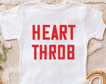 May include: White t-shirt with the words "HEART THROB" printed in red.