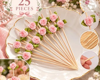 May include: A set of 25 decorative food picks featuring small light pink fabric roses with green ribbon leaves attached to thin wooden skewers. The picks are arranged on a white scalloped plate, with additional views showing the rose detail and pointed tips.