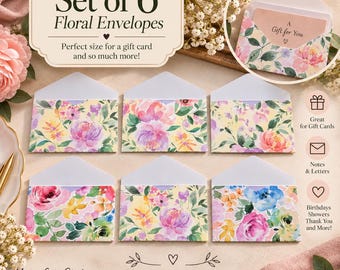 May include: A set of six floral envelopes featuring watercolor-style pink, purple, yellow, and green flower patterns. The envelopes have a pointed flap and are displayed with text that reads Set of 6 Floral Envelopes and Fits a Gift Card.